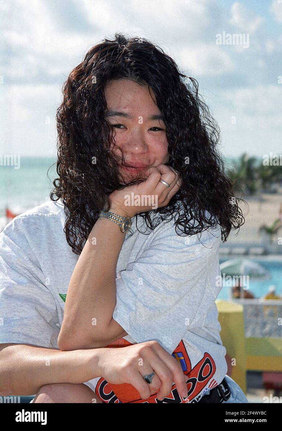 Asian American woman out in the sun by the beach Stock Photo