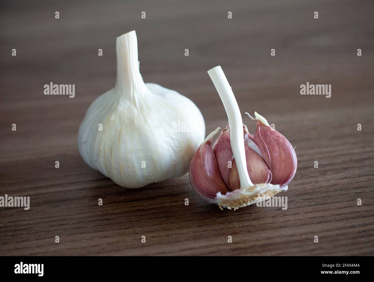 Garlic bulb and cloves over wood background Stock Photo - Alamy