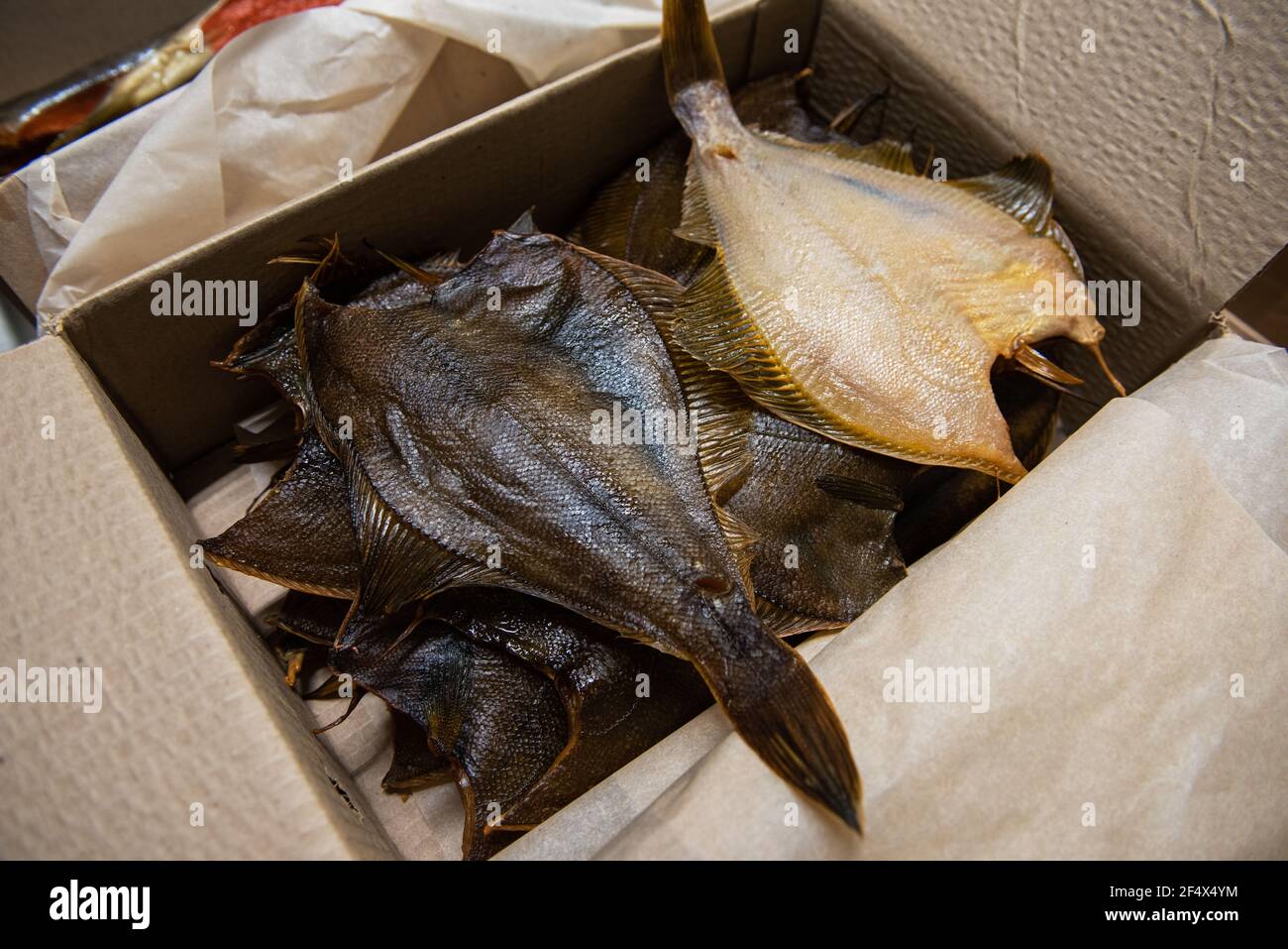 Smoked fish in craft paper box. Ready for delivery production. Smoked fish production concept