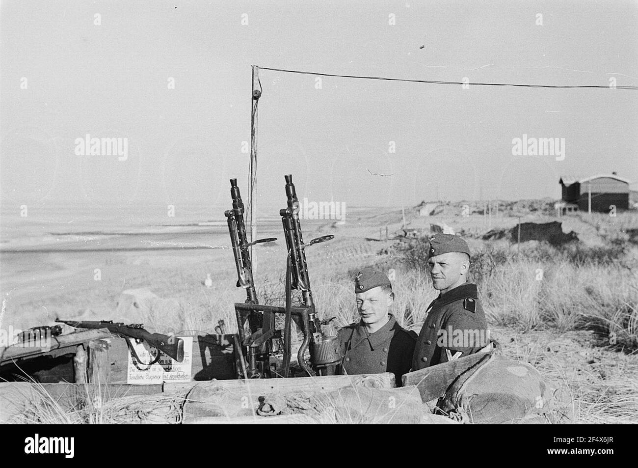 Second World War. Netherlands under German crew. Two relatives of the German Wehrmacht at a twin socketafette 36 with MG 34 and carabiner 98k in a trench in dunes on the North Sea (probably at the Hague) Stock Photo
