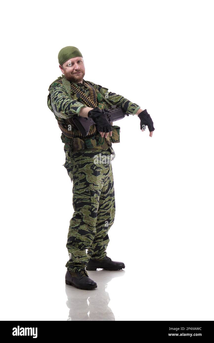 Man actor in the form of an American fur seal posing with a machine gun in his hands on a white background. Special Forces in Vietnam, 1970's. Stock Photo