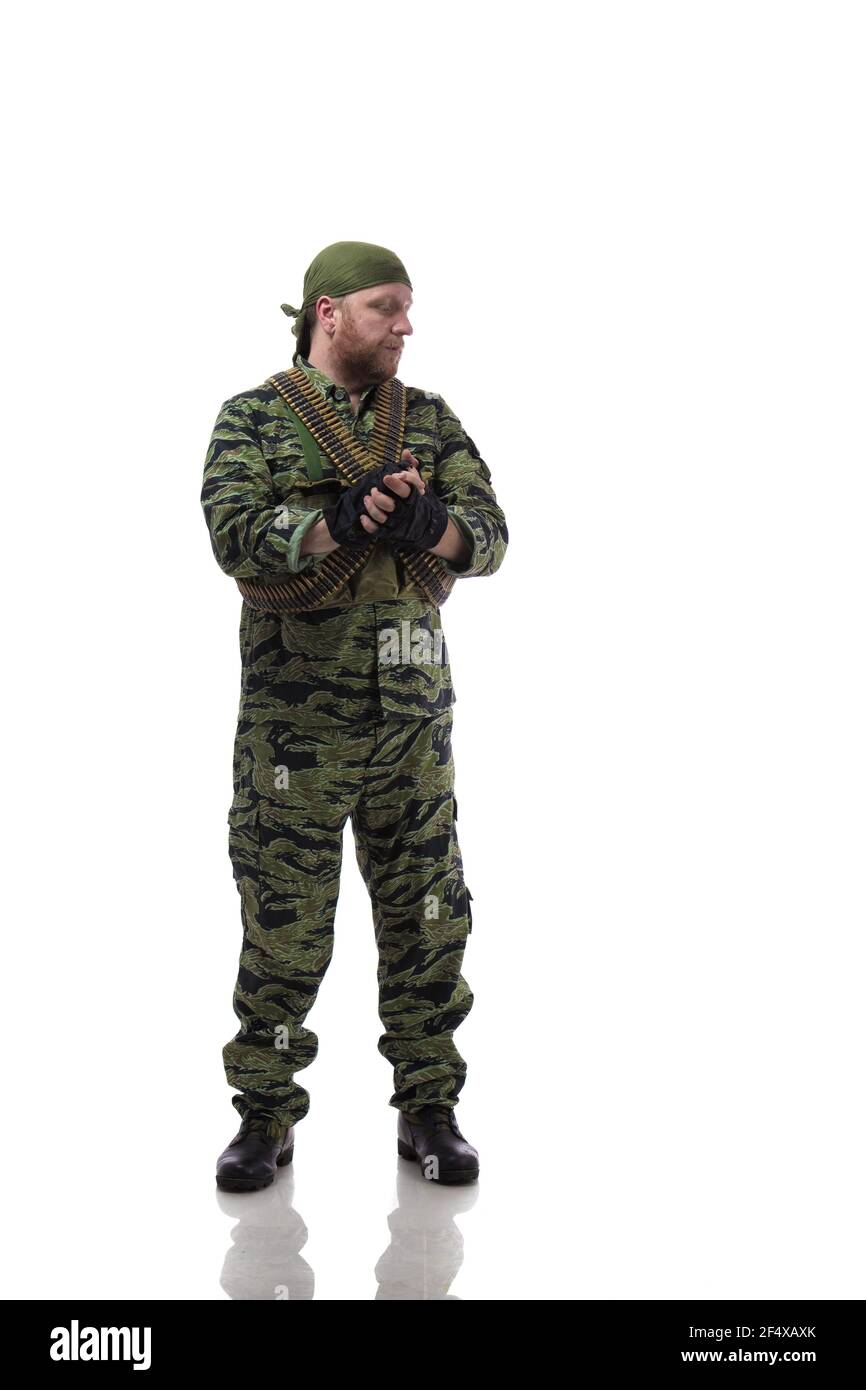 Man actor in the form of an American fur seal posing with a machine gun in his hands on a white background. Special Forces in Vietnam, 1970's. Stock Photo