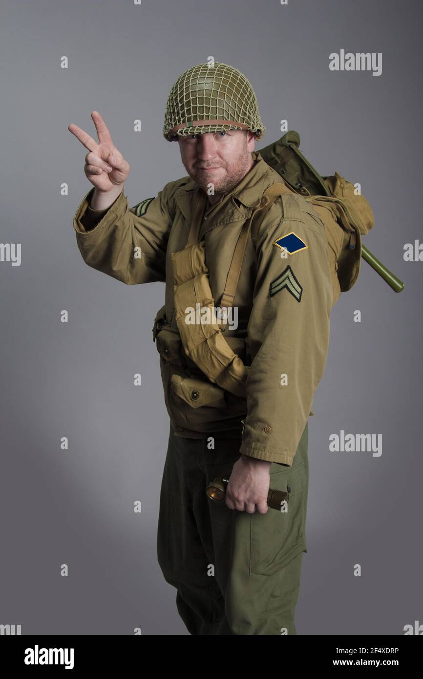 The man is an actor in the military uniform of an American ranger, wearing a helmet and with a carbine in his hands, the period of the World War II is Stock Photo