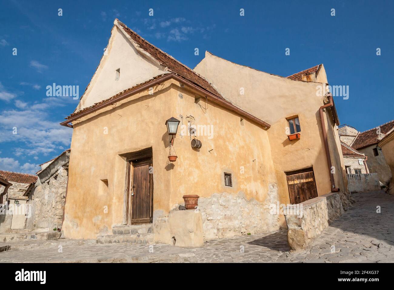 Inside courtyard and old houses of The Rasnov Citadel, little medieval fortress in traditional romanian style near Brasov city. Traditional medieval house in Transylvania region of Romania. Stock Photo