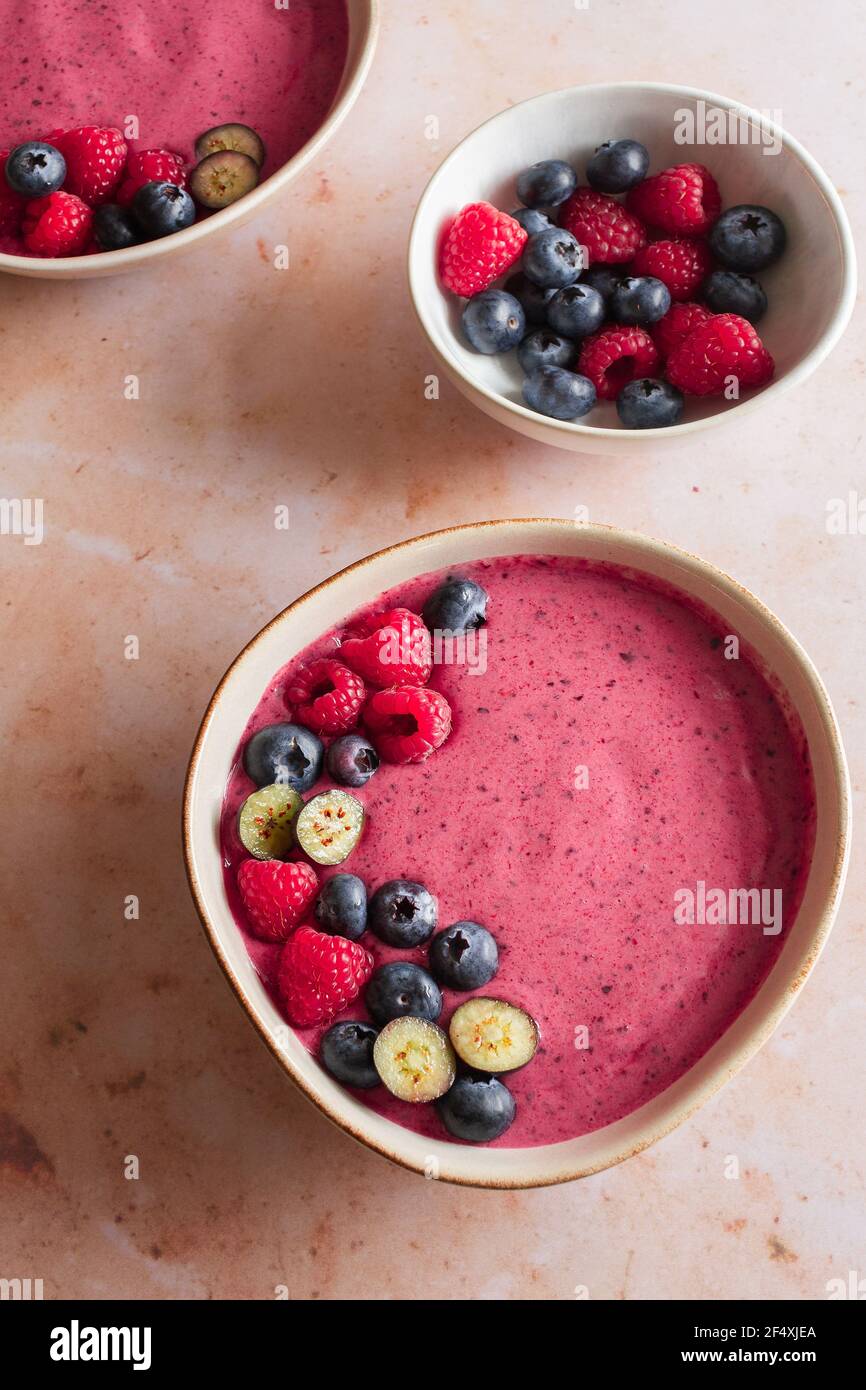 Two berry smoothie bowls with fresh raspberries, blueberries and almonds. Stock Photo