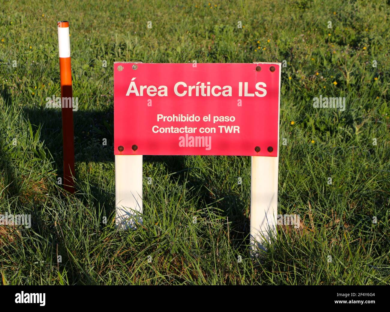 Small red warning sign for the Instrument Landing System ILS at the Seve Ballestero Santander Airport Cantabria Spain Morning sun Stock Photo