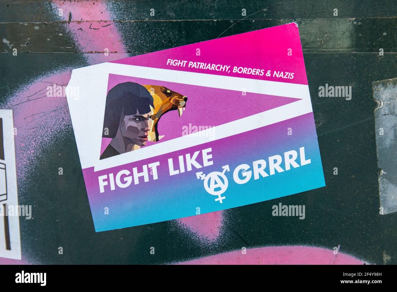 Fight like a grrrl. Sticker on a public trash bin. Stock Photo