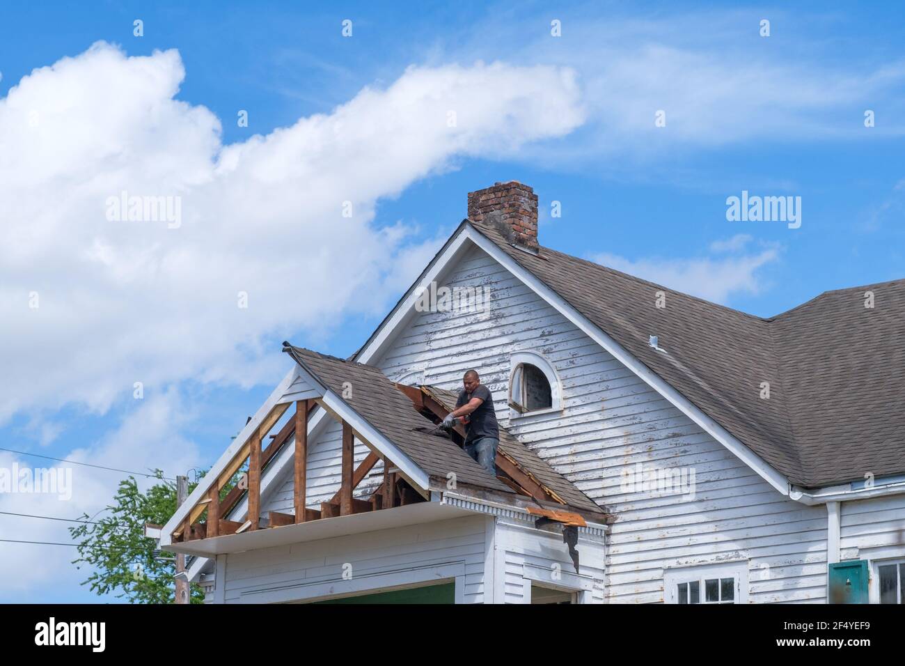 NEW ORLEANS, LA, USA - MARCH 22, 2021: Worker demolishing section of house in preparation for remodeling Stock Photo