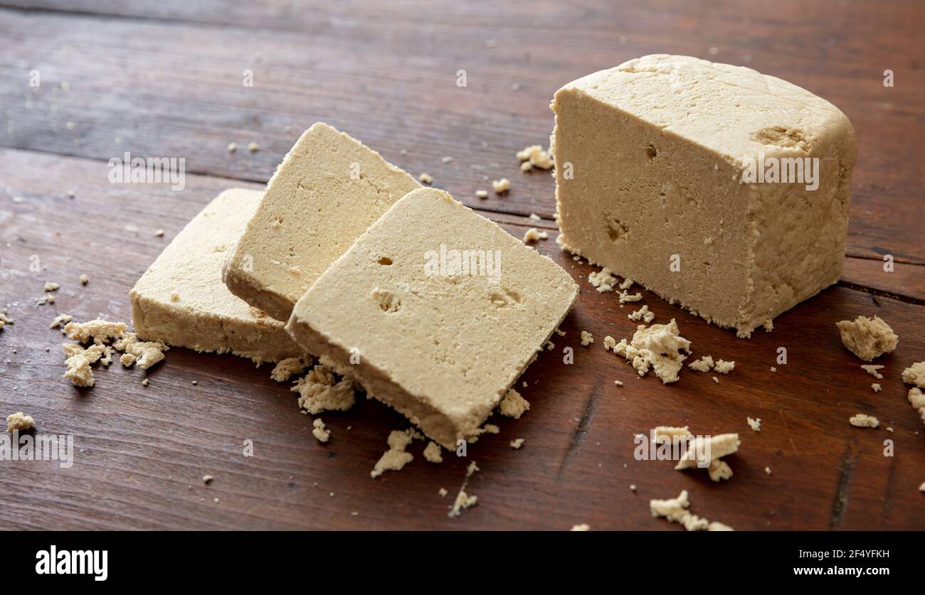 Halva sunflower seeds pieces on wooden table background, closeup view