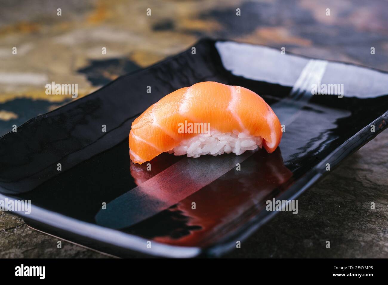 Delicious Sushi Nigiri with Salmon (Sake) on black plate. Traditional