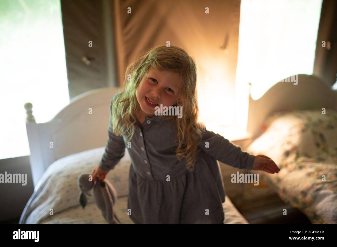 Portrait cute girl with stuffed animal on bed Stock Photo - Alamy