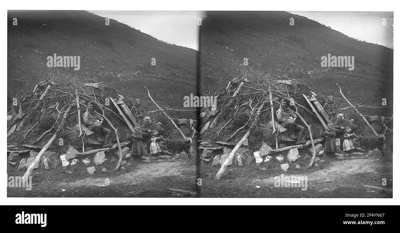 At Tromsø / Norway: seed family in front of her hut. Seed family with small children and dog in front of their earth block hut at the foot of a mountain Stock Photo