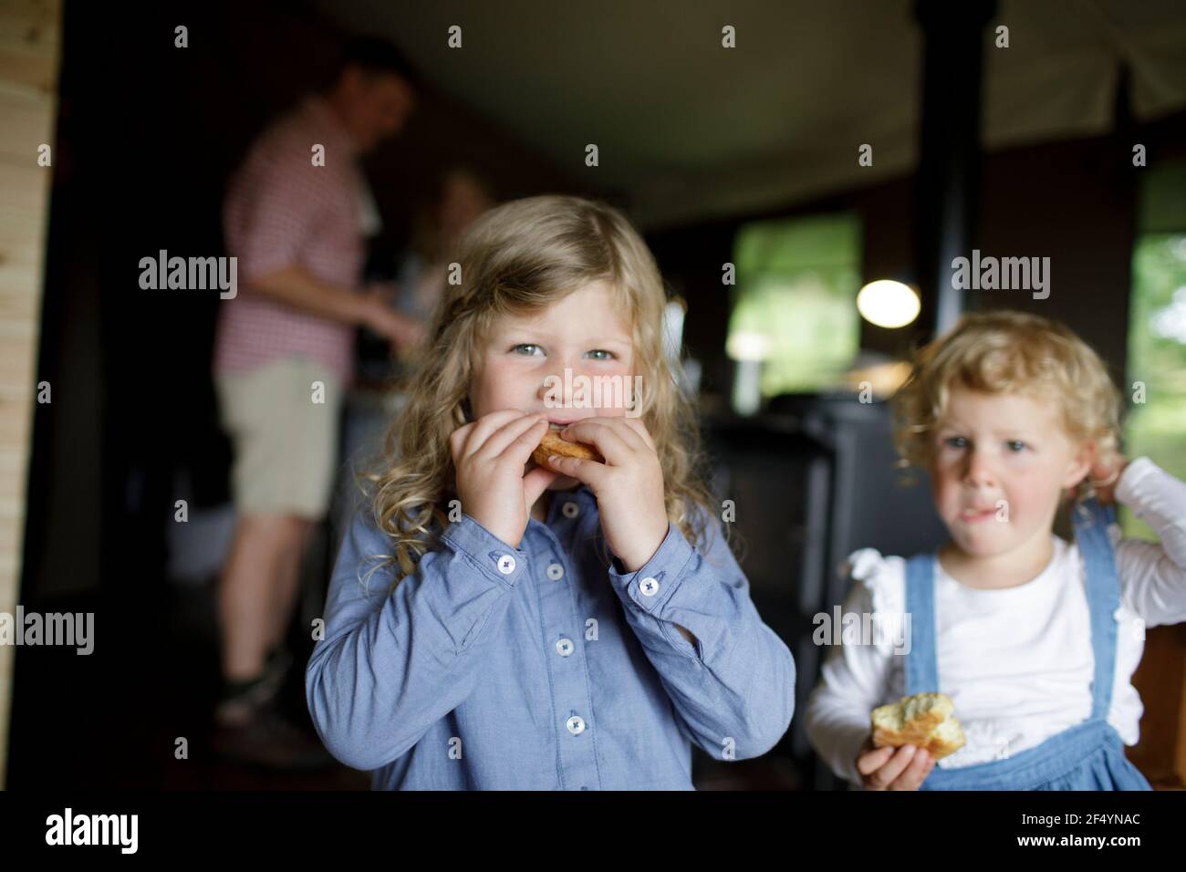 Portrait cute sisters eating biscuits in cabin Stock Photo
