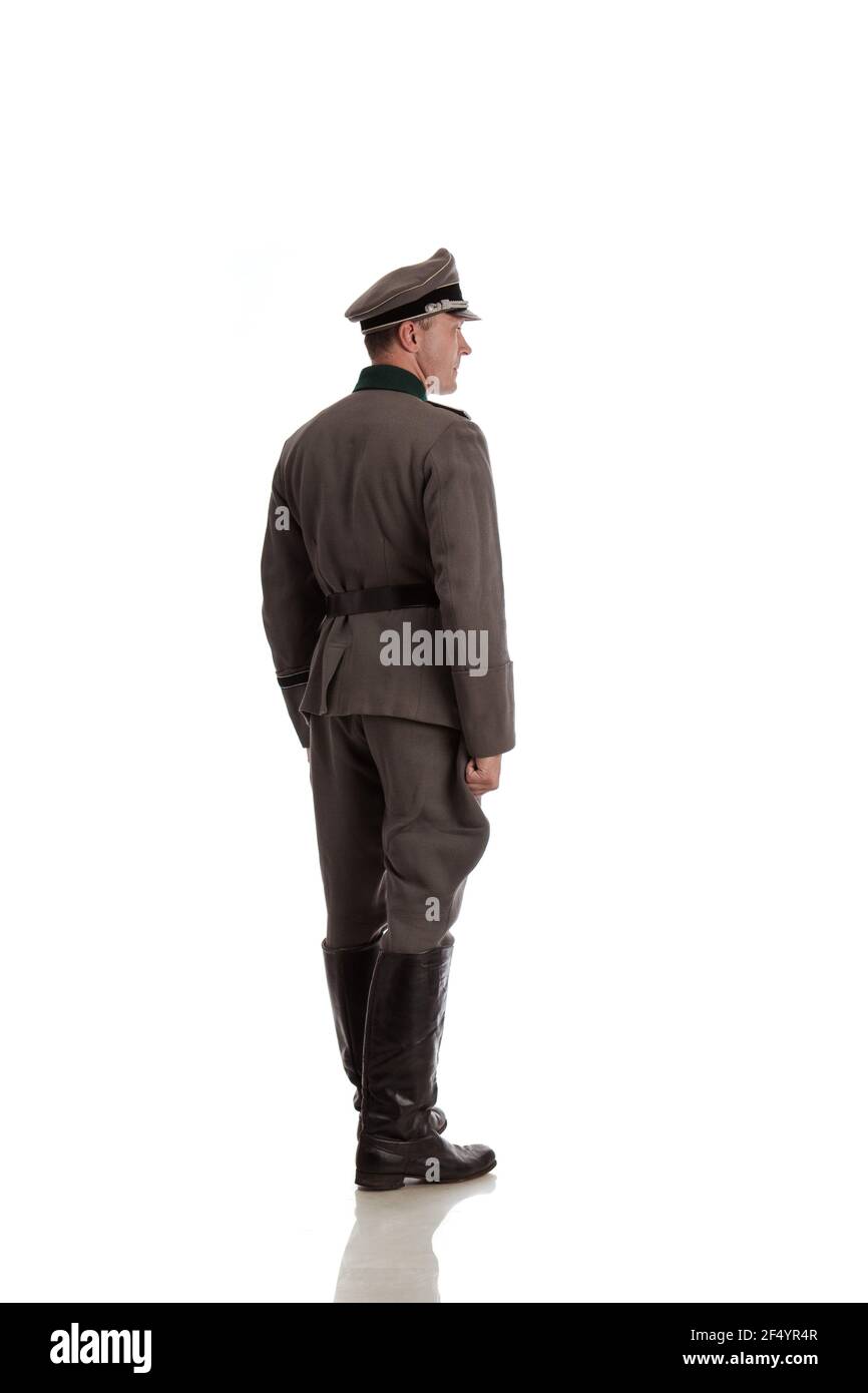 Man actor in historical military uniform as an officer of the German Army during World War II, posing on a black background in a blue scenic light Stock Photo