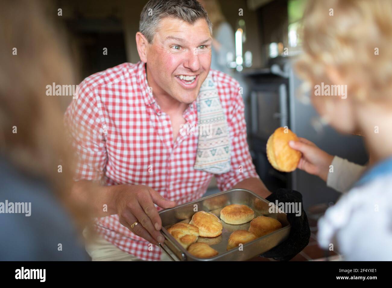 Happy father feeding biscuits to daughters Stock Photo