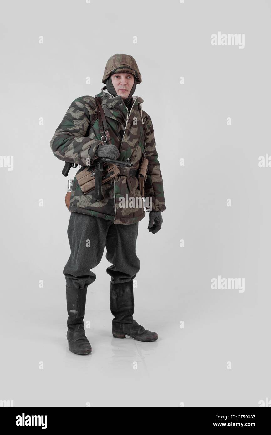 male actor movie in the role in the winter military uniform of an old soldier, the period 1942, the Second World War, posing on a gray background Stock Photo