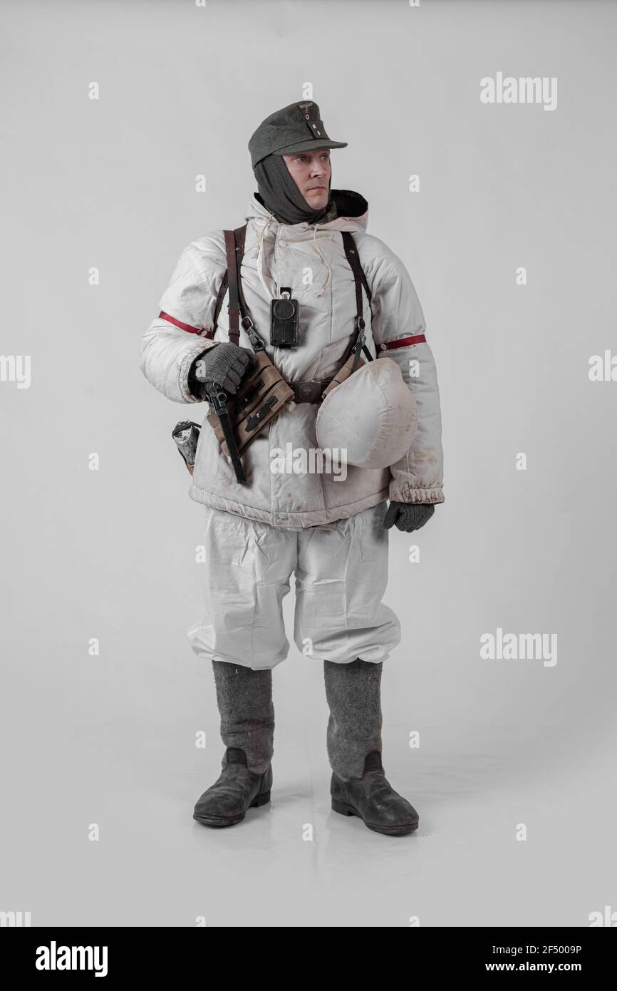 male actor movie in the role in the winter military uniform of an old soldier, the period 1942, the Second World War, posing on a gray background Stock Photo