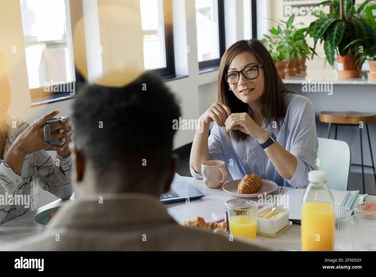 Business people talking over breakfast in office meeting Stock Photo