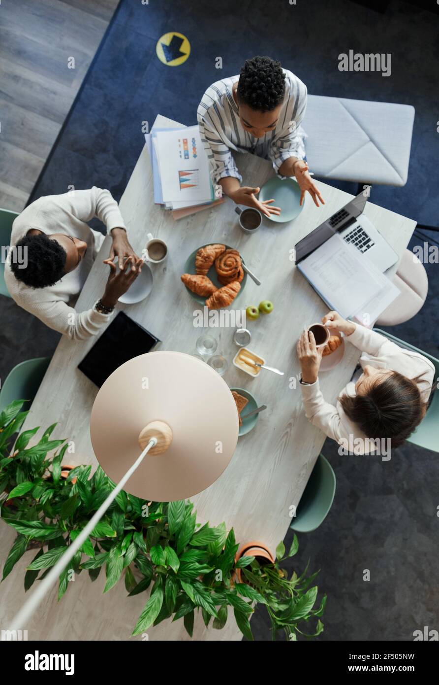 Business people talking over breakfast in office meeting Stock Photo