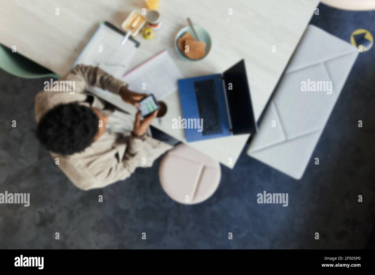 Businessman using smart phone at laptop in office Stock Photo