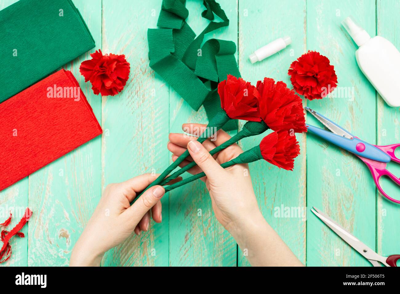 How to make a carnation flower at home. Hands make a red carnation