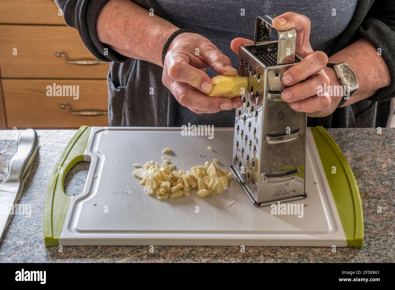 Woman grating root ginger to make chutney. Stock Photo