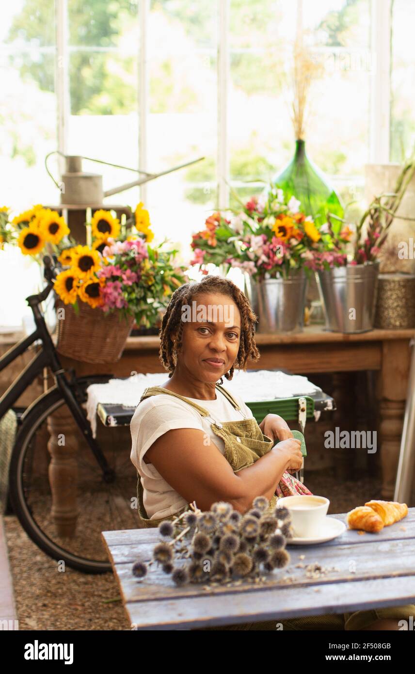 Portrait confident female florist taking coffee break in flower shop Stock Photo