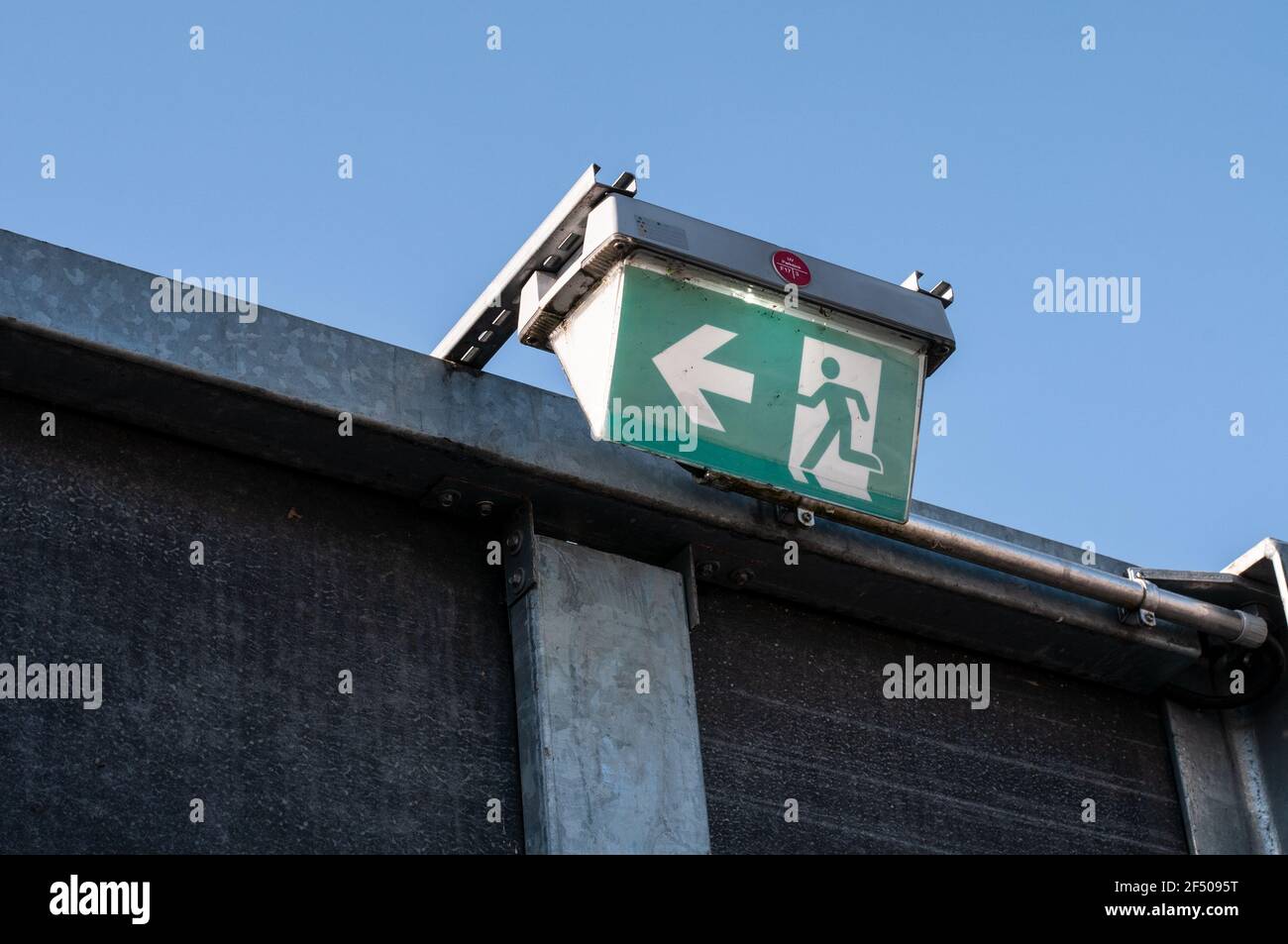 an illuminated emergency exit sign at an outdoor staircase at a parking lot  Stock Photo - Alamy