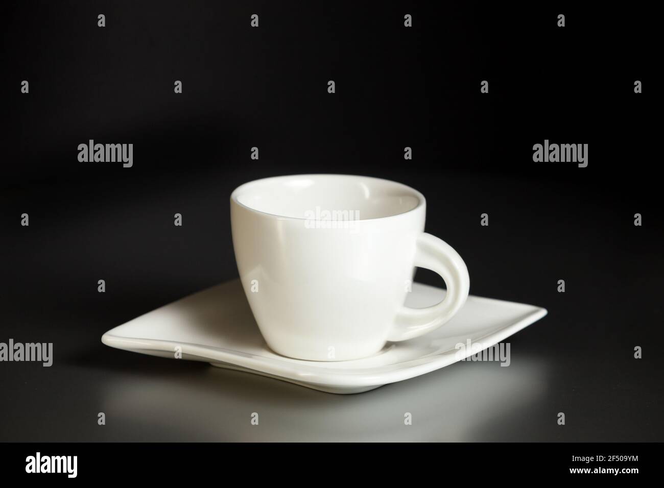 Coffee ceramic cup and saucer on a gray table against a black wall. Coffee break, rest. Close-up. Stock Photo