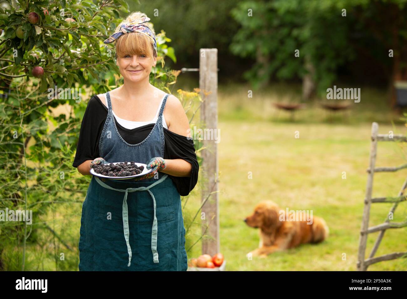 Portrait proud woman with blackberries in summer garden Stock Photo