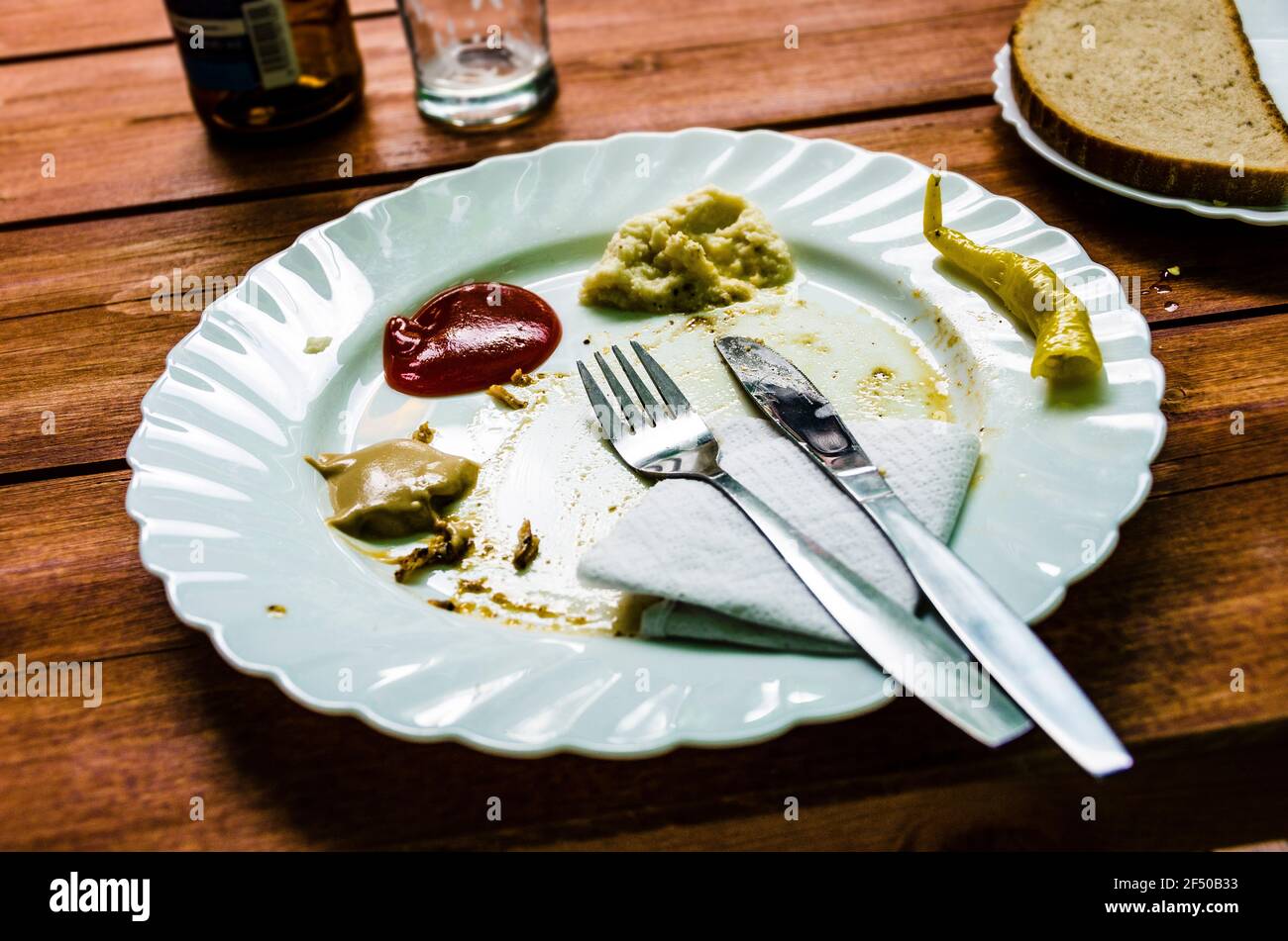 Dirty plate after the meal finished with untouched ketchup, mustard and