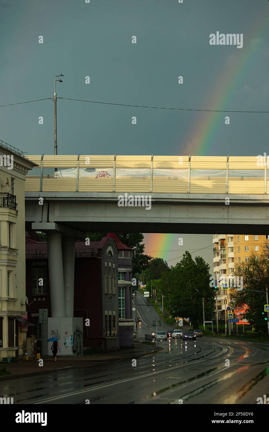 rainbow in the sky over the city after the rain. an old steam locomotive stands at the railway station Stock Photo