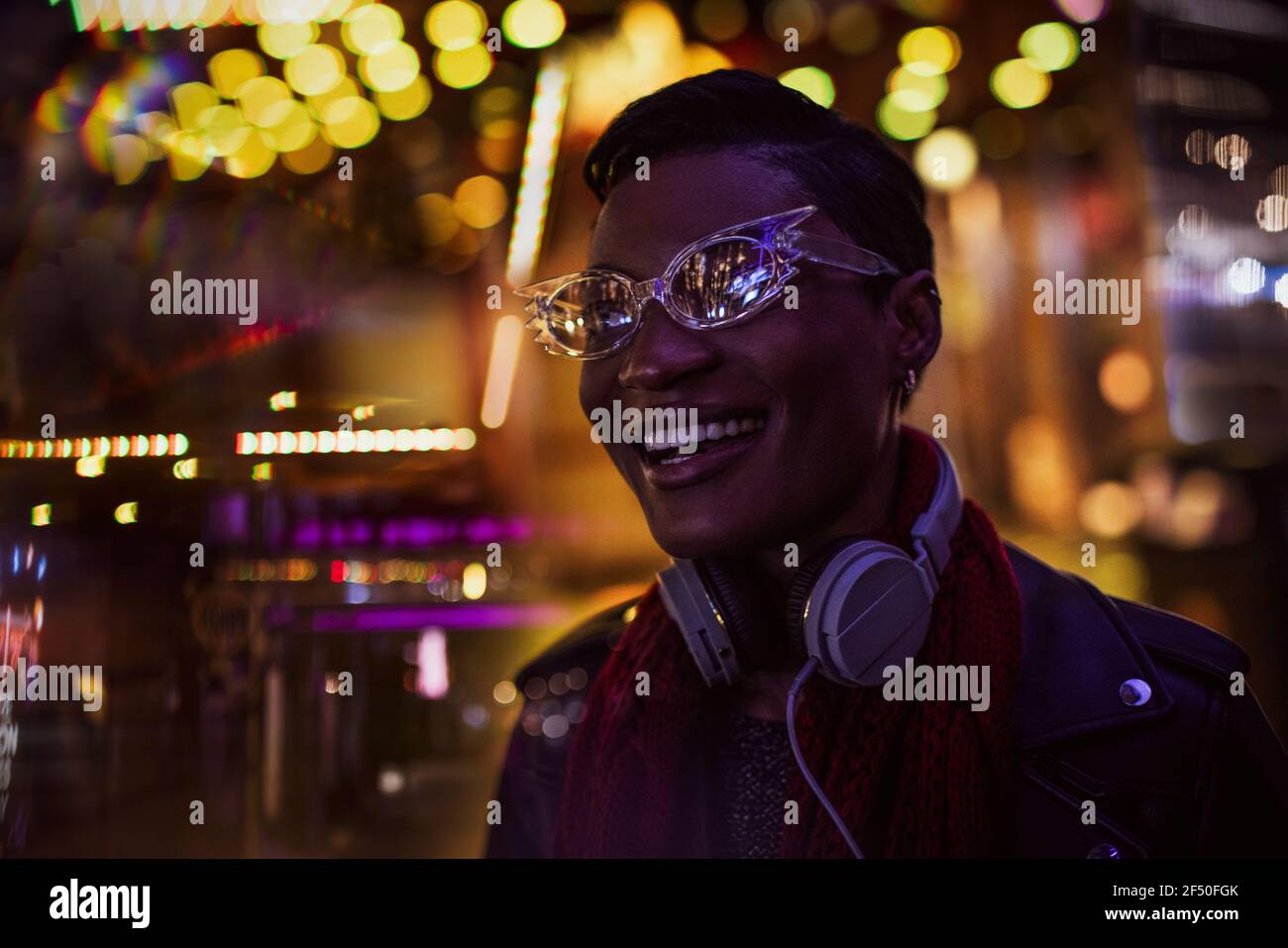 City lights around happy young woman in funky eyeglasses Stock Photo