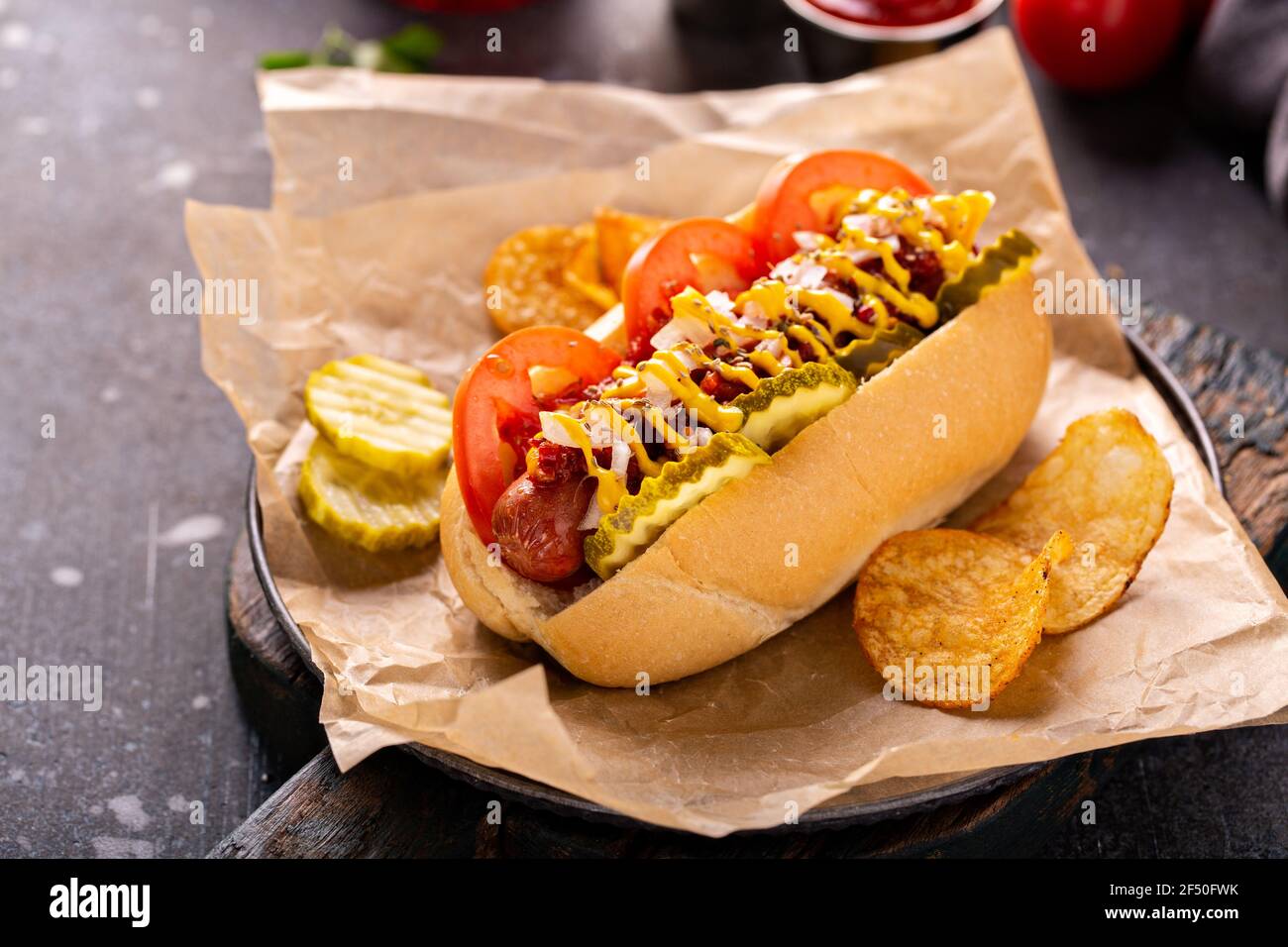 Hot dog with tomatoes, mustard and pickles Stock Photo Alamy