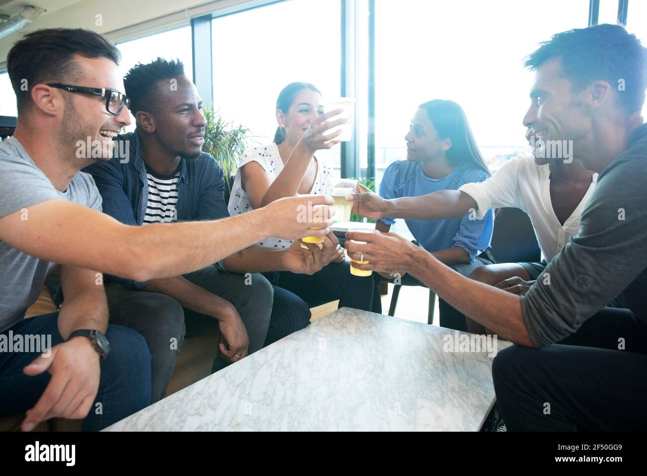 Diverse group of business people enjoying beers in office Stock Photo