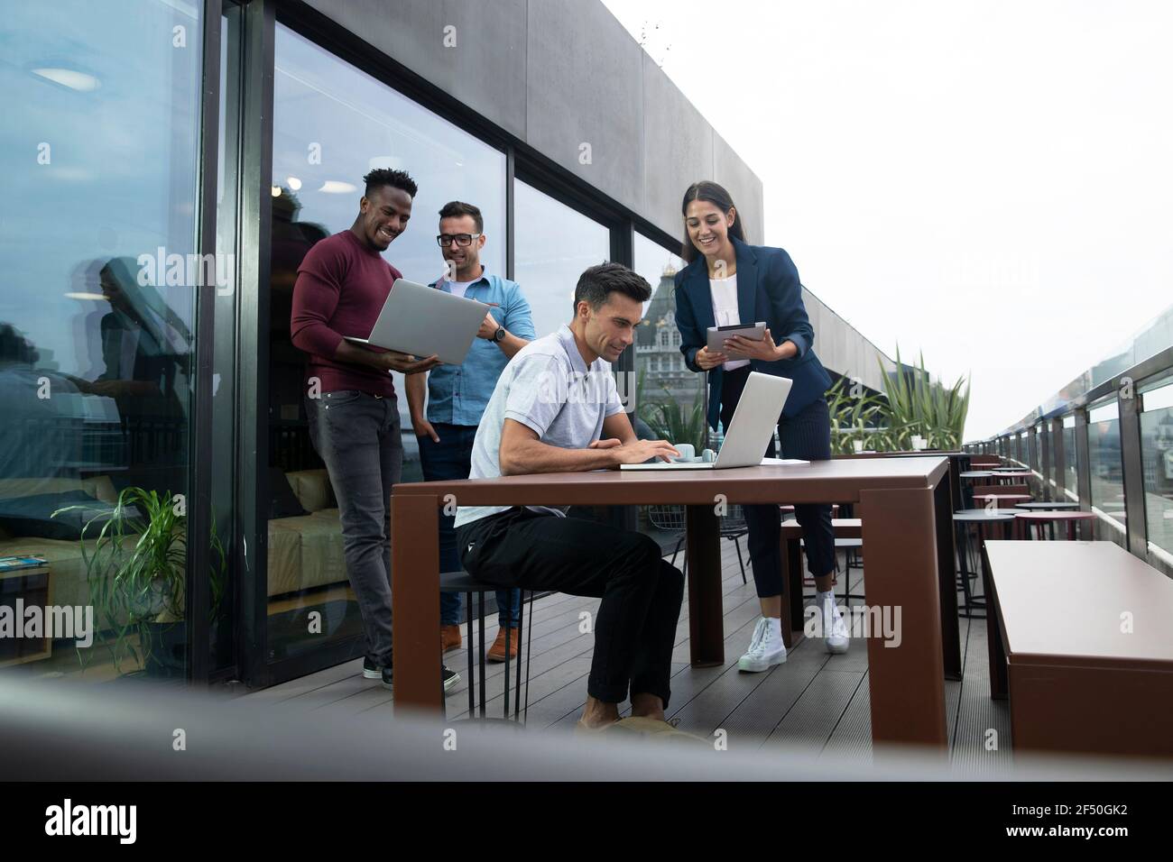 Business people working with laptops and digital tablet on balcony Stock Photo