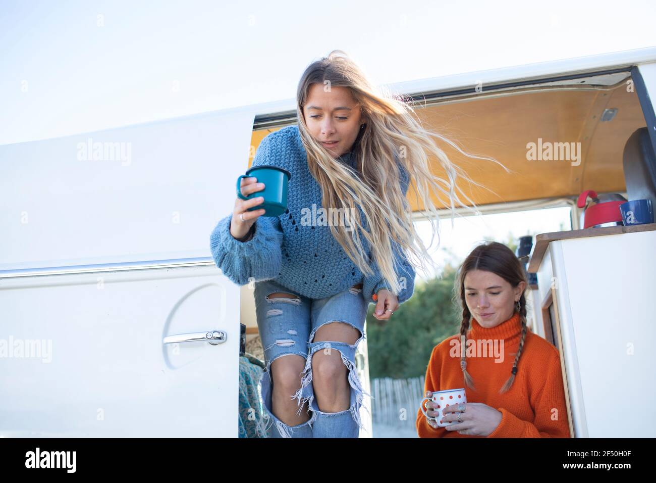 Young women friends drinking coffee in camper van Stock Photo