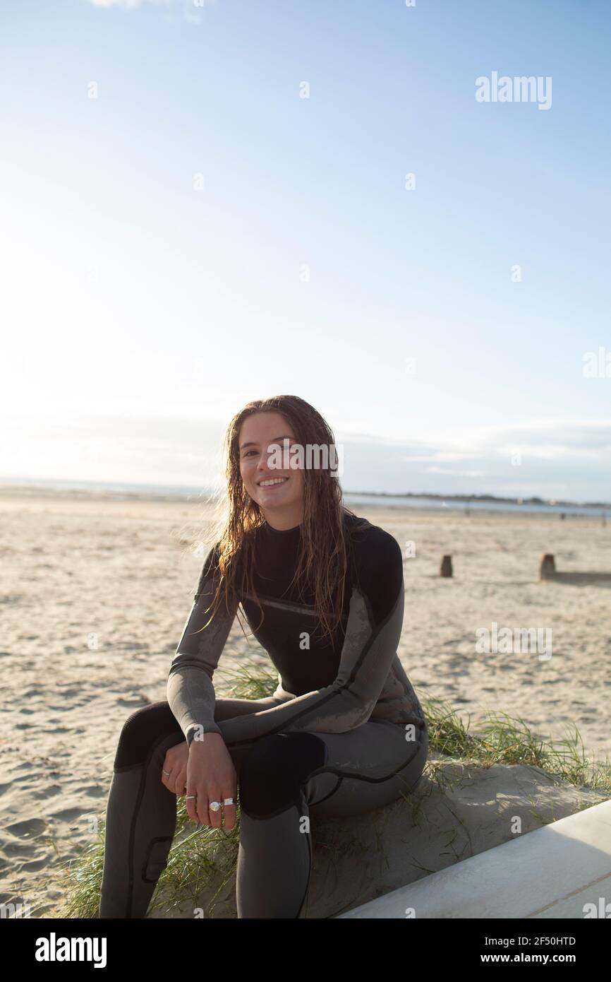 Portrait confident beautiful young female surfer in wet suit on beach Stock Photo