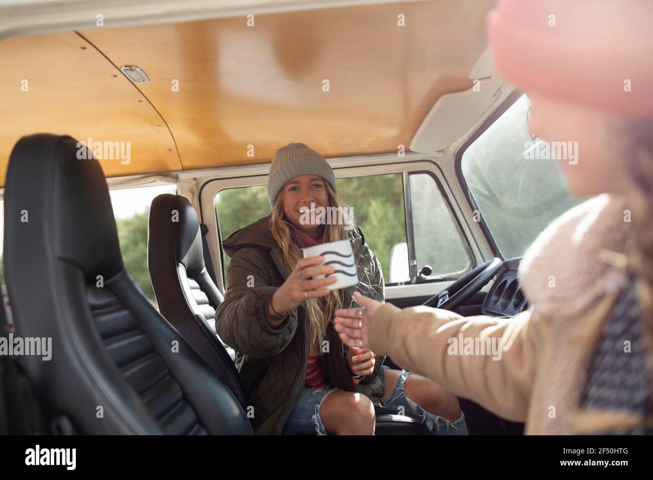 Happy young women friends enjoying coffee in camper van Stock Photo