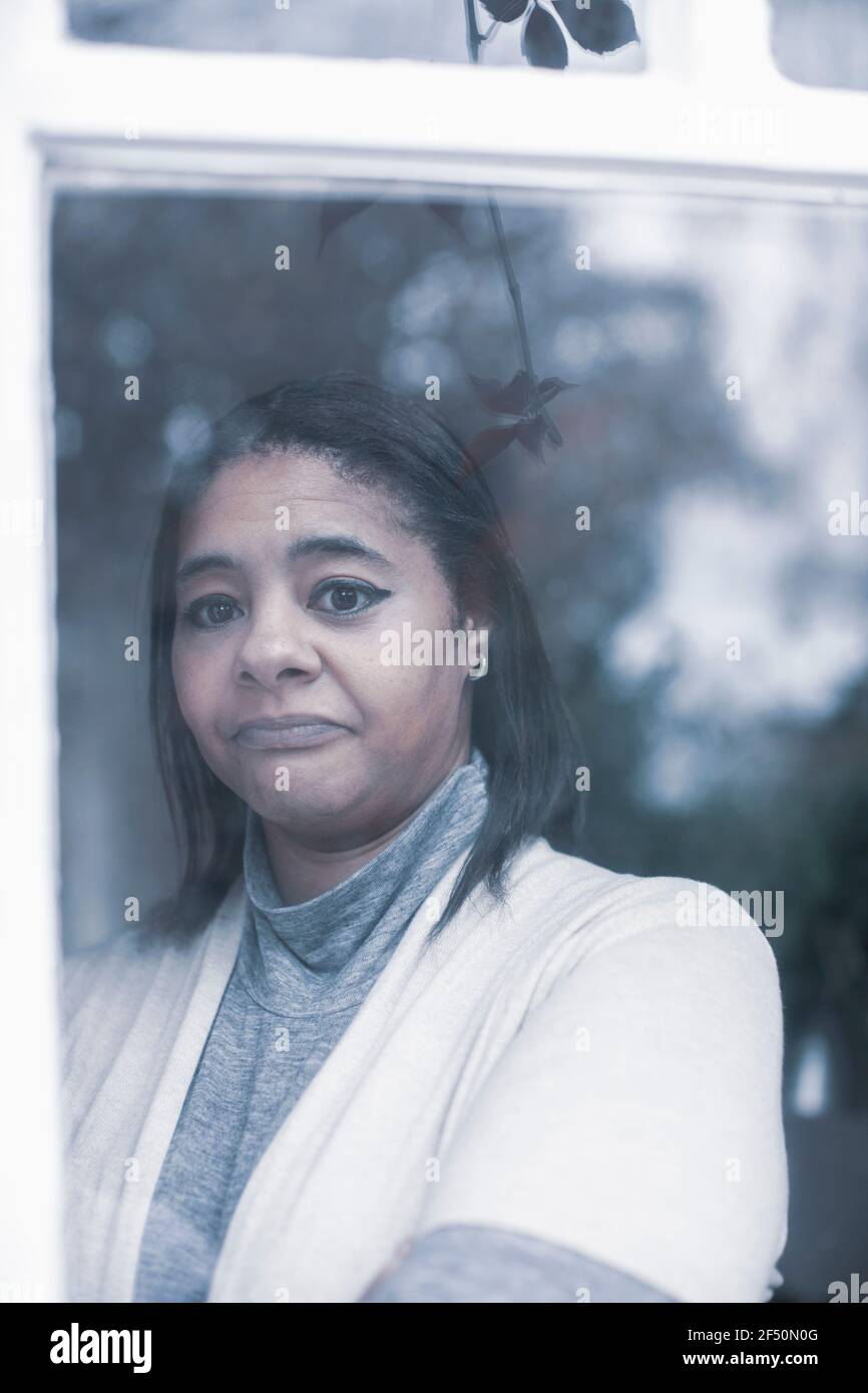 Portrait sad woman at window Stock Photo