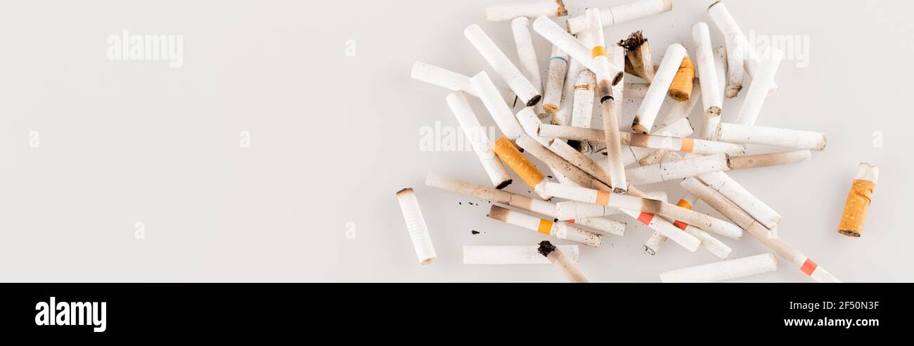 top view of cigarette ends on white surface, ecology concept, banner Stock Photo