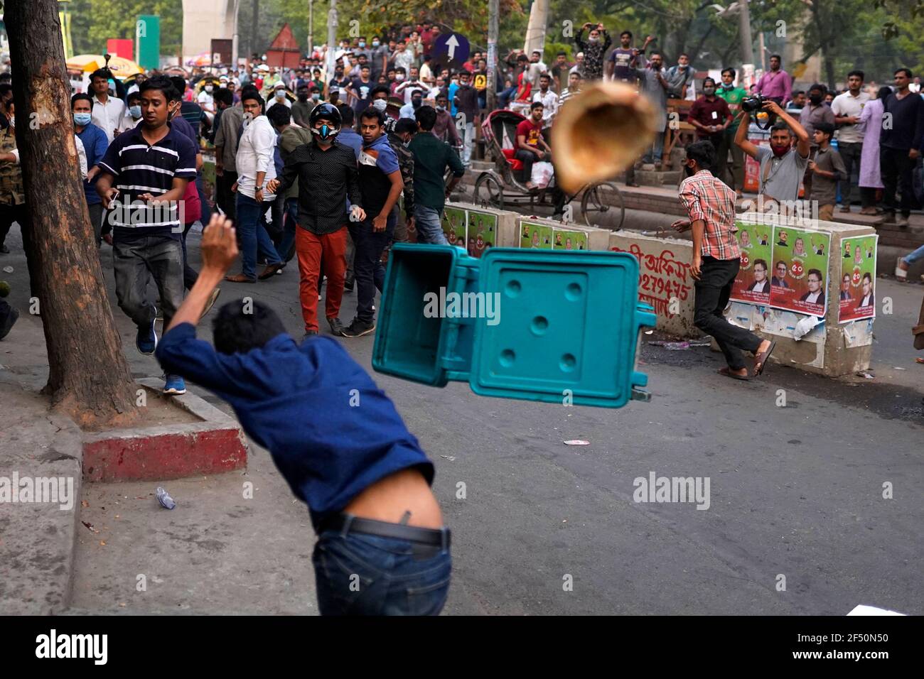 A counter protester throwing a trash can at protesters during a demonstration against the upcoming visit of Indian Prime Minister, Narendra Modi to Bangladesh to attend the golden jubilee celebrations of the country's independence. Stock Photo