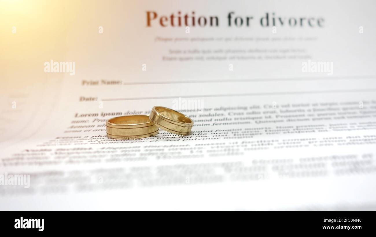 Conceptual image for divorce with two golden wedding rings in the