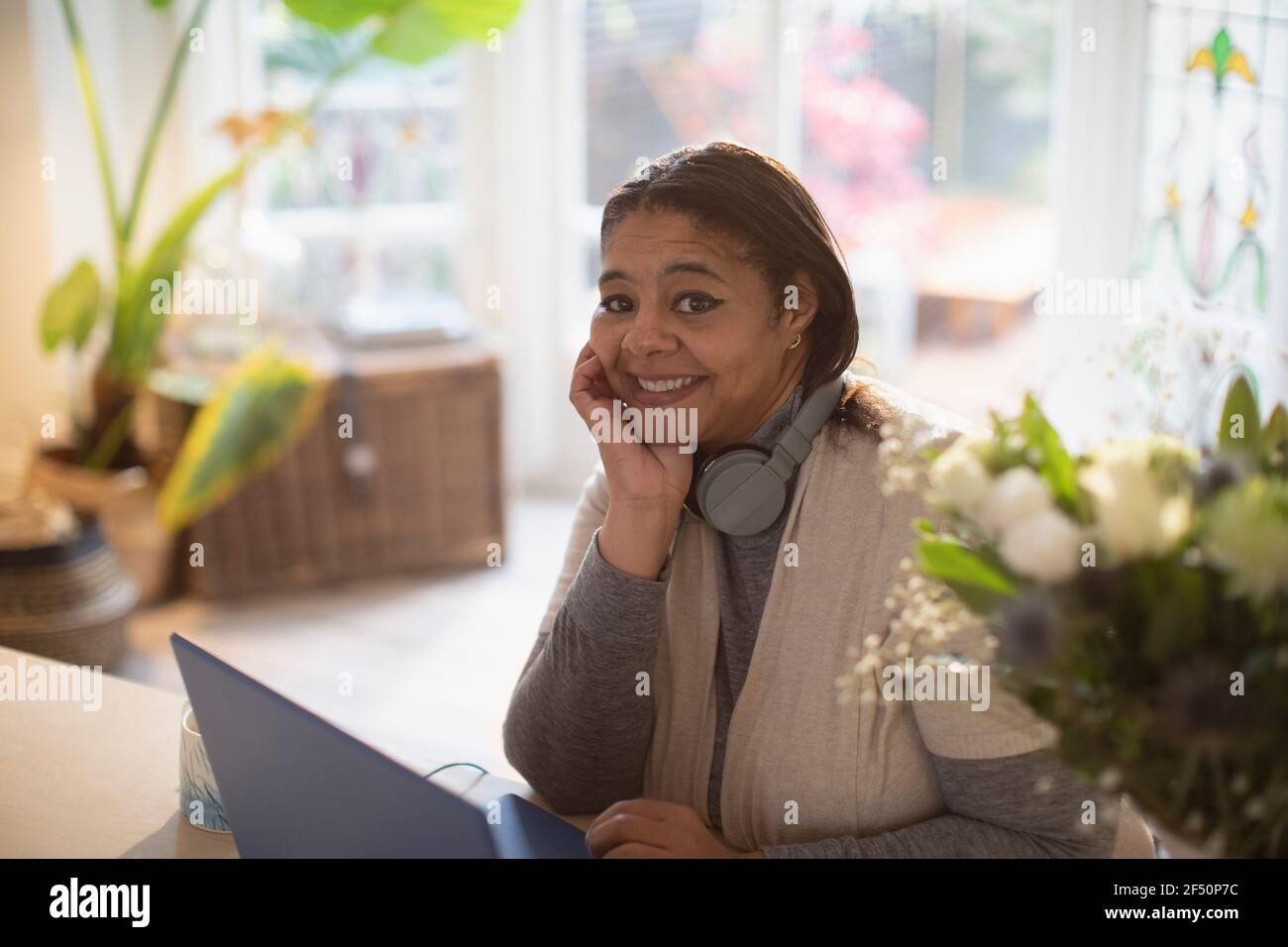 Portrait happy woman working from home at laptop Stock Photo