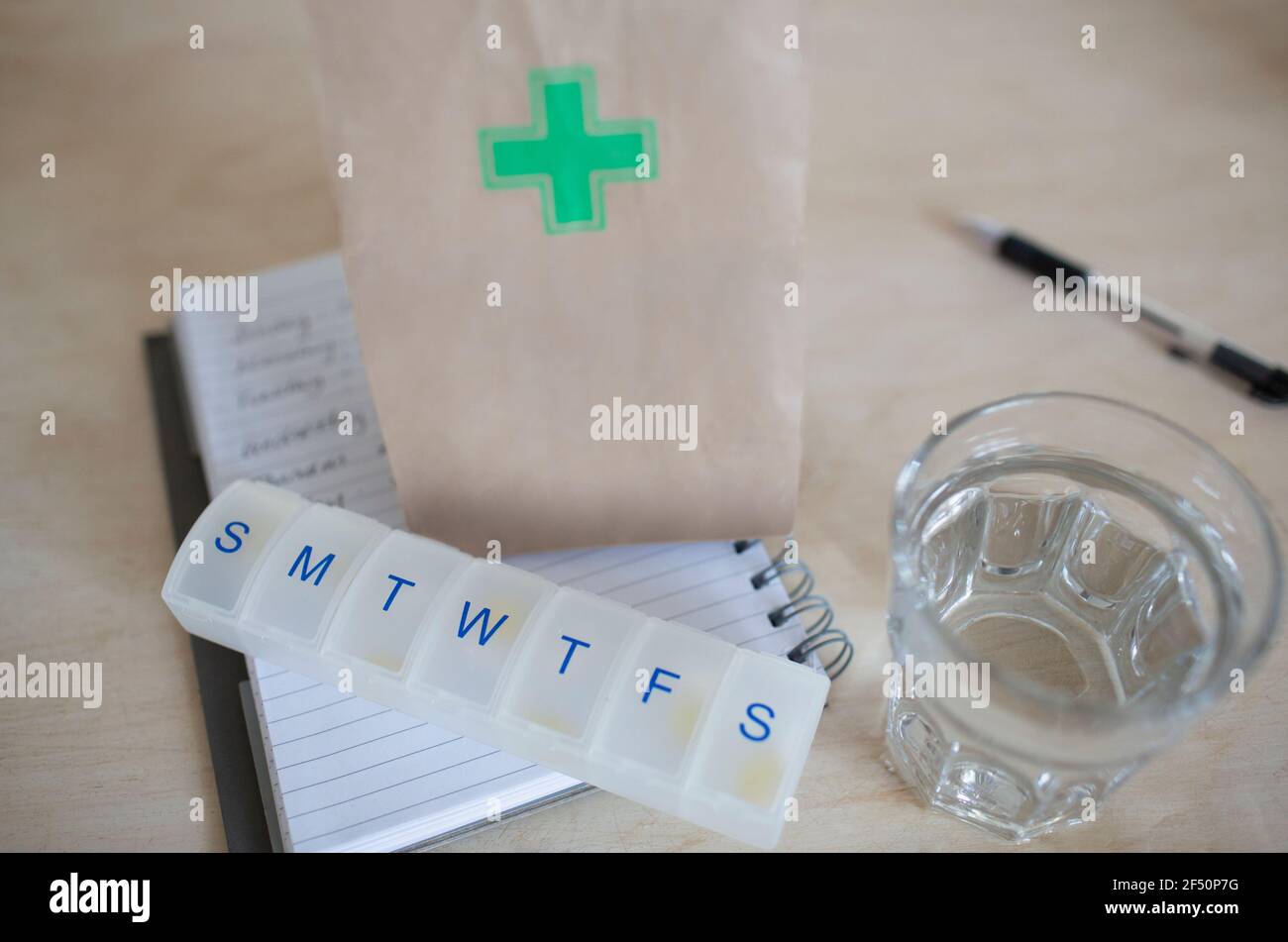 Prescription bag and pill box with glass of water Stock Photo