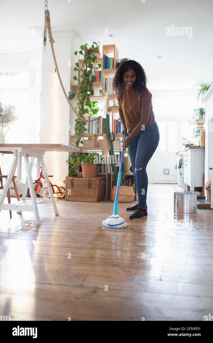 Woman mopping hardwood floor in apartment Stock Photo