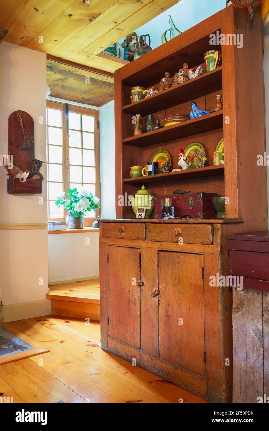 Antique pine wood buffet decorated with ceramic plates, cups, old