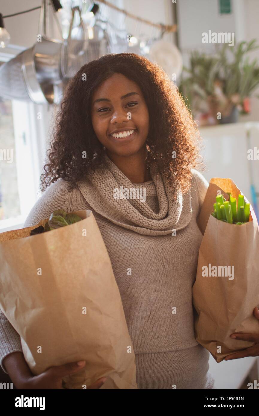 Portrait happy young woman with grocery bags Stock Photo