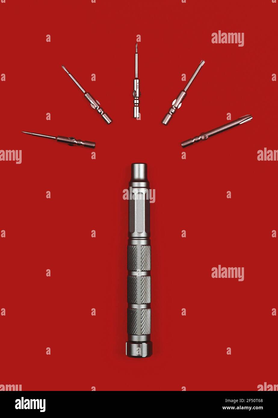 Screwdriver Bit Red Color Screwdriver with bits on a red background, flat lay photo of equipments ...