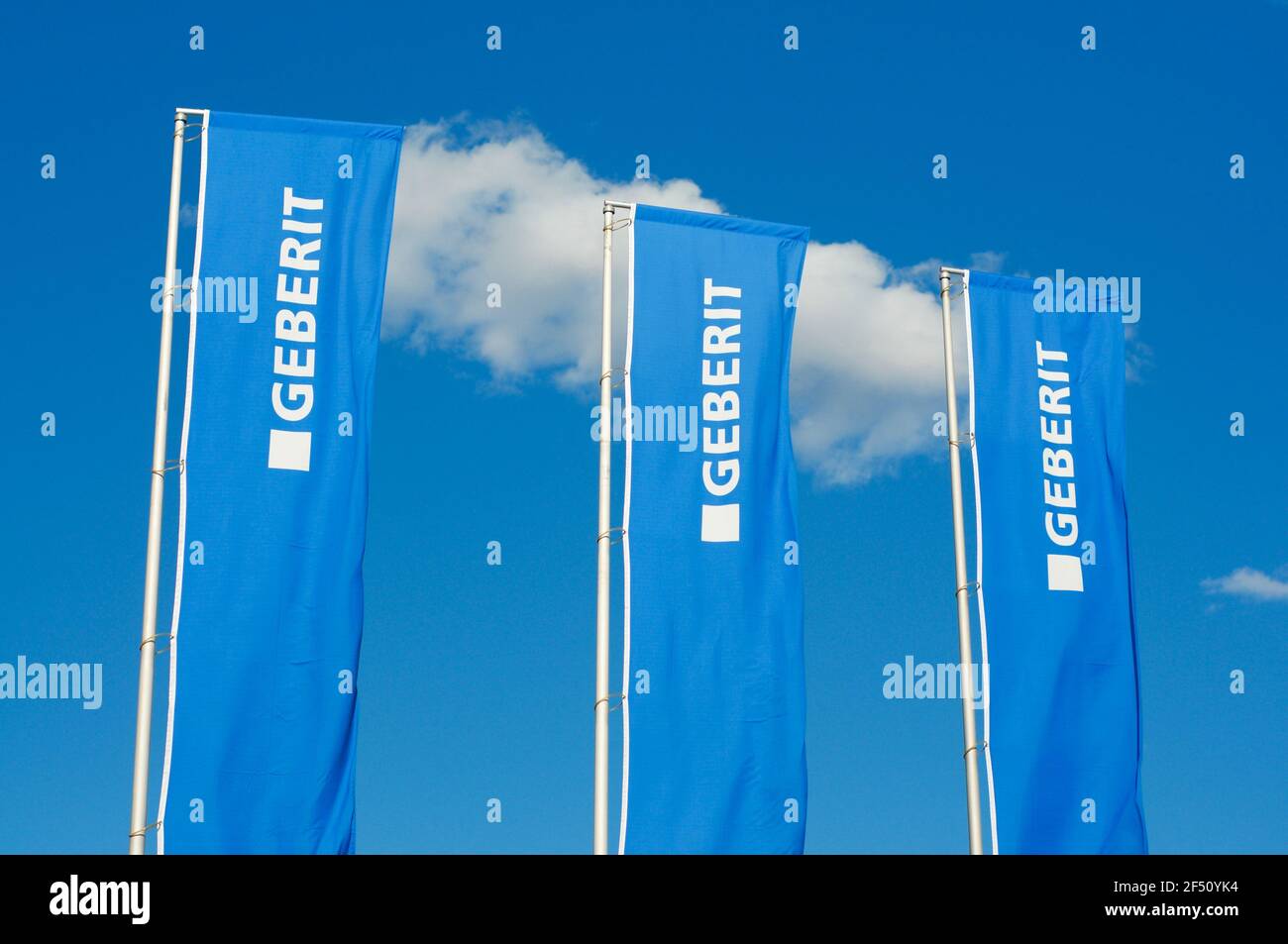 Manno, Switzerland - 18th March 2021 : View of three Geberit company flags against blue sky in Switzerland. Geberit is a Swiss multinational specializ Stock Photo